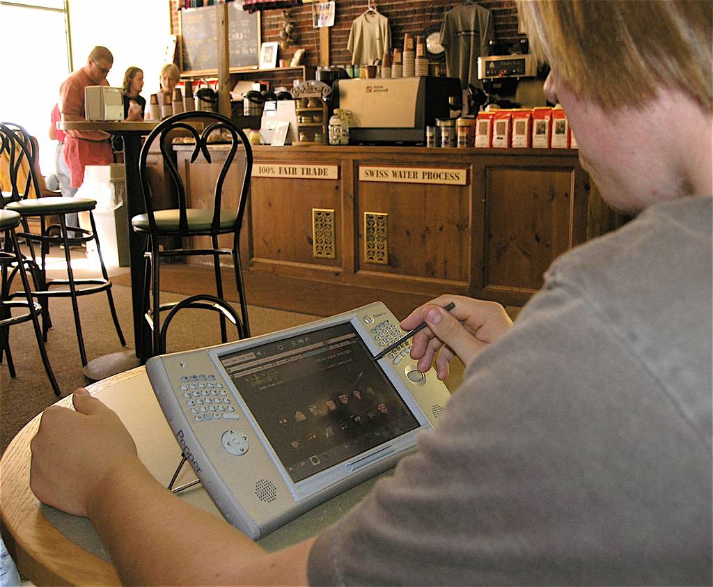Person using a device to work at coffee shop