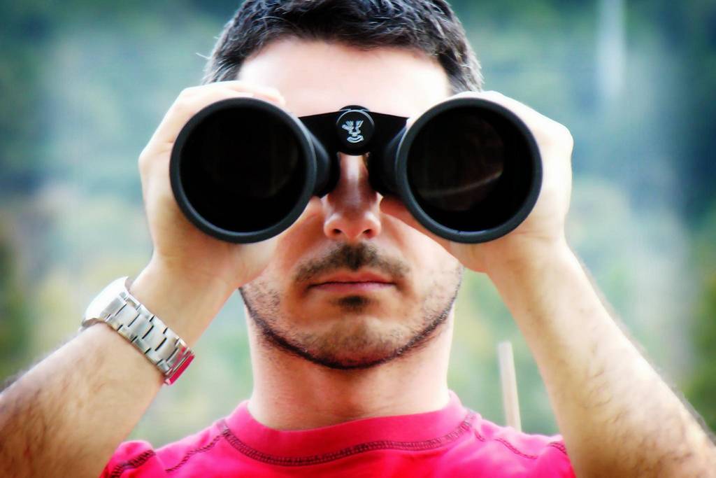 hide your personal information on the internet Man looking into binoculars