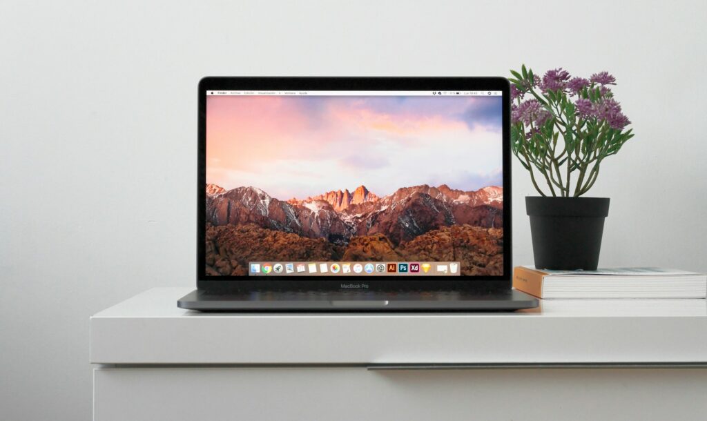 MacBook on a table with flowers in the background