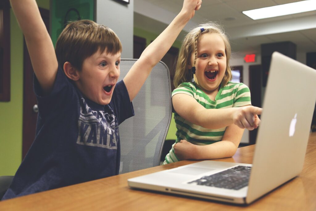 Kids cheering at a laptop.