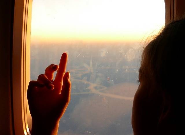 Girl looking out airplane window.