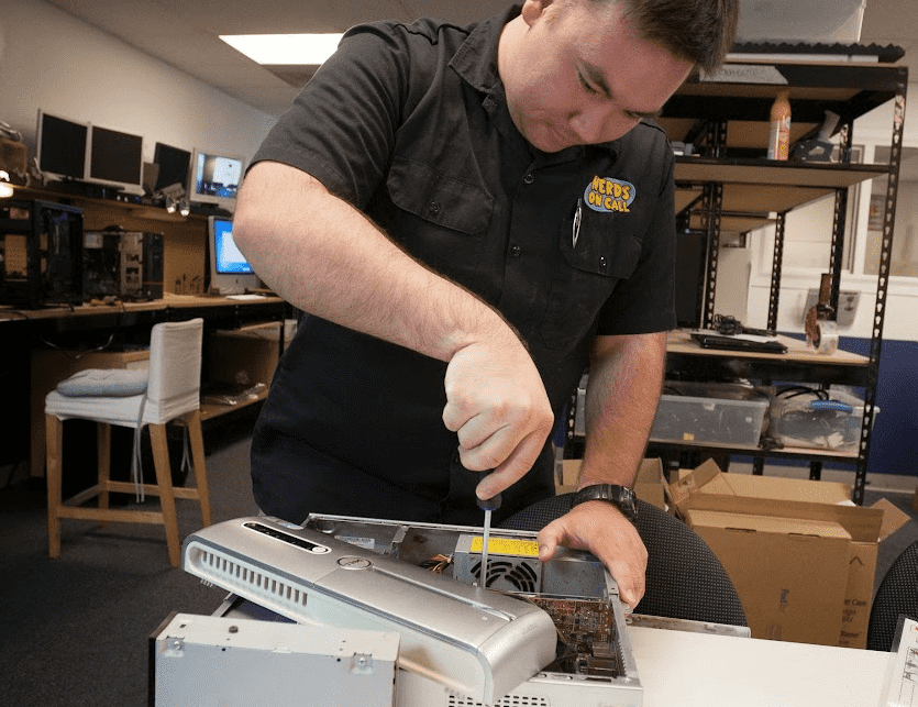 Nerds On Call tech working on PC tower.