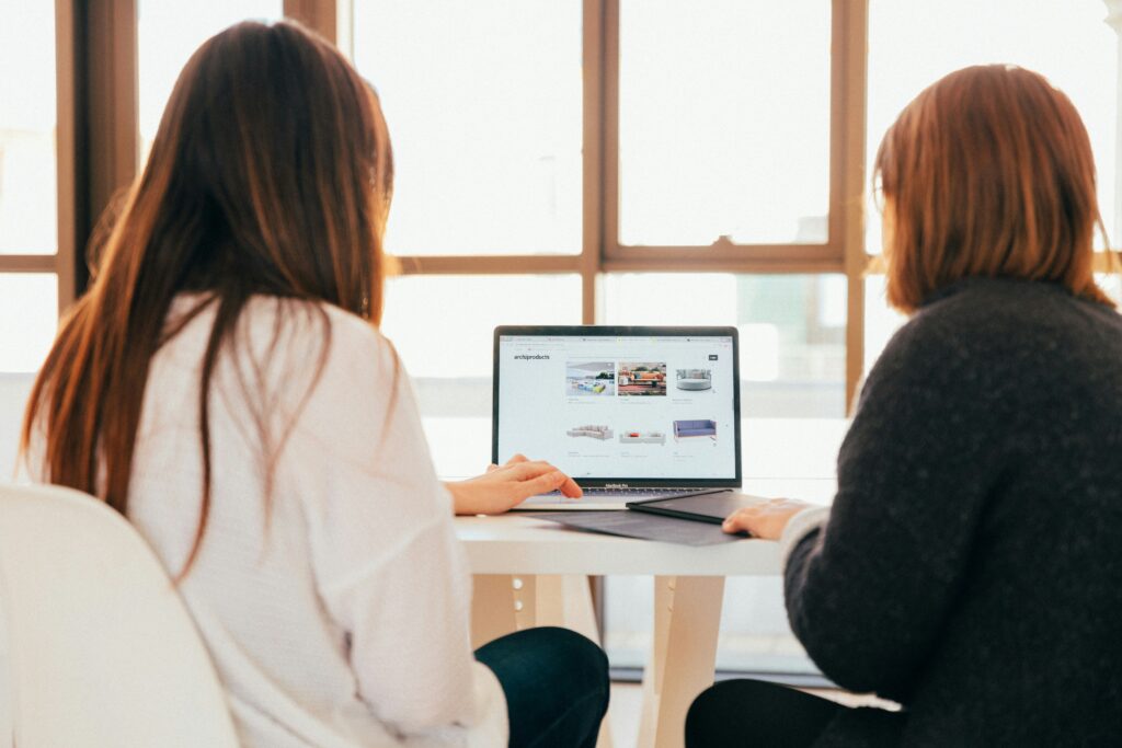 Computer support Near Me: Two women around a laptop on table.