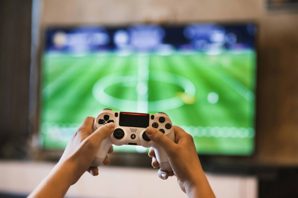 Gamer playing a soccer game on a console not experiencing PlayStation overheating