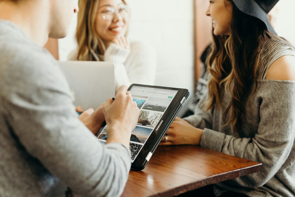 People at a table, one holding a Samsung Galaxy tablet