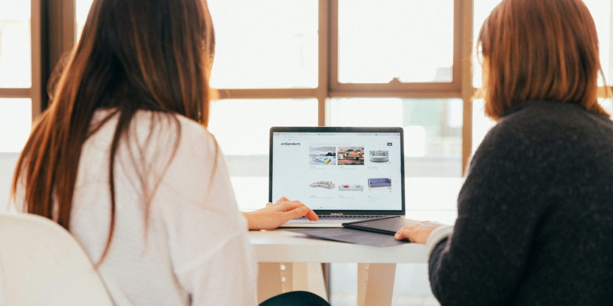 Computer support Near Me: Two women around a laptop on table.